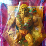 Close-up detail of He-Man action figure on 1983 card, with comic behind toy